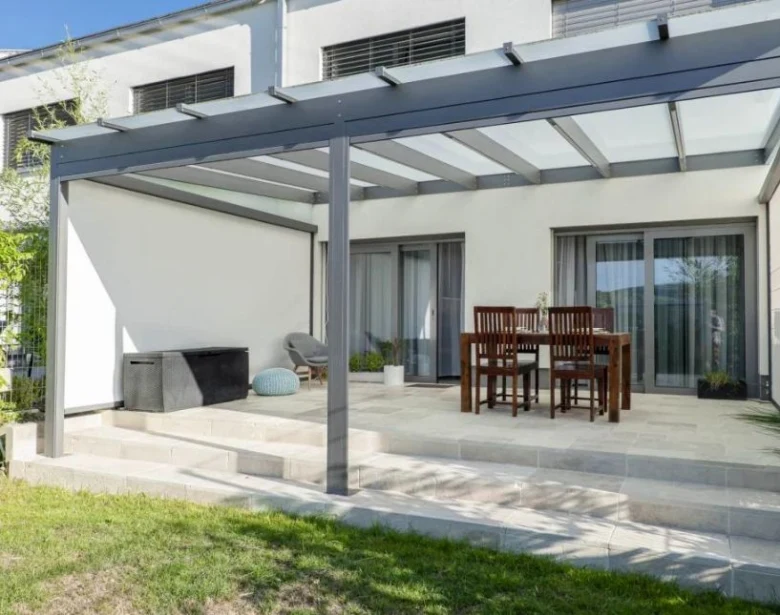 Moderní kovová pergola na terase s venkovním jídelním setem.