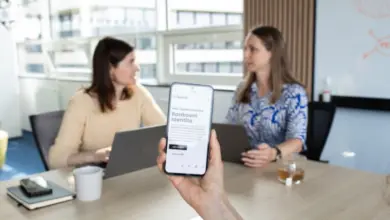 Ruka drží chytrý telefon s aplikací pro online daňové přiznání.