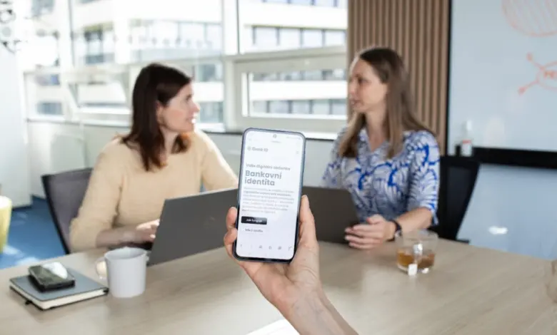 Ruka drží chytrý telefon s aplikací pro online daňové přiznání.
