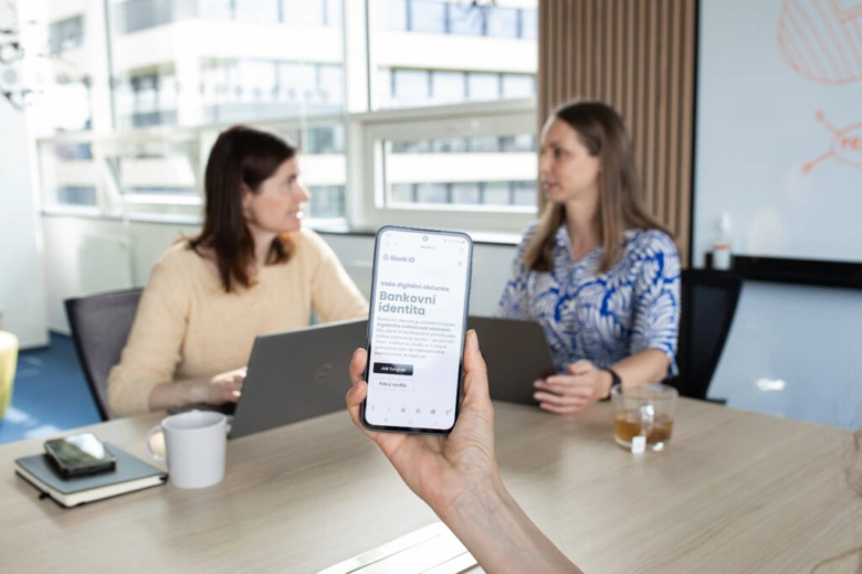 Ruka drží chytrý telefon s aplikací pro online daňové přiznání.