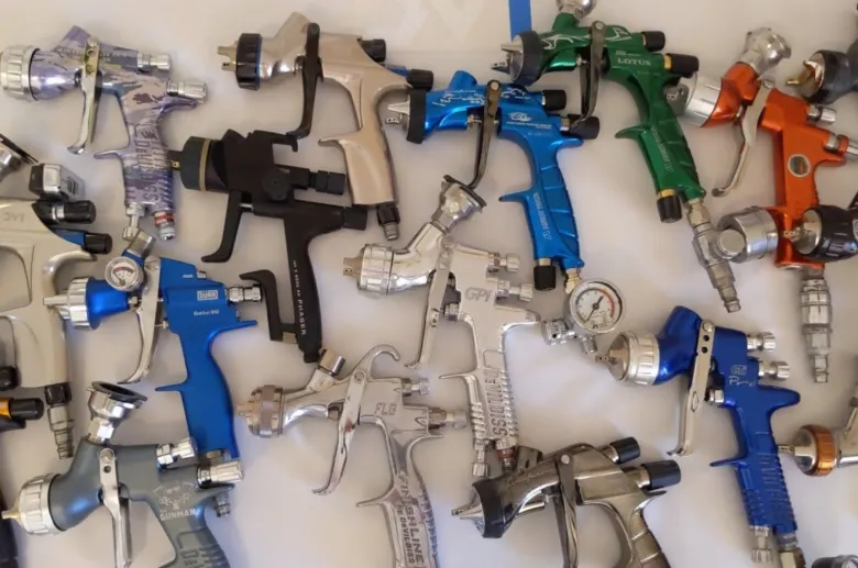 Různé typy stříkacích pistolí na malování uspořádané vedle sebe.