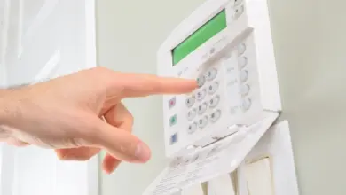Ruka tlačí na klávesnici zabezpečovacího systému u přepínačů.