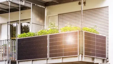Fotografie fotovoltaických panelů na balkóně s rostlinami.
