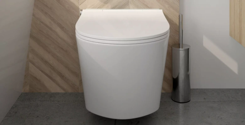 Bílá WC s uzavřeným poklopem vedle čistícího štětce.