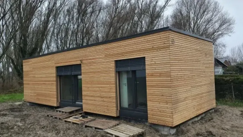 Moderní modulový dům z dřeva na nezpevněném pozemku.