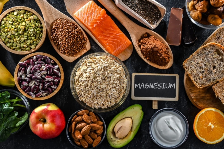 Různé potraviny bohaté na hořčík uspořádané vedle tabule s nápisem MAGNESIUM.