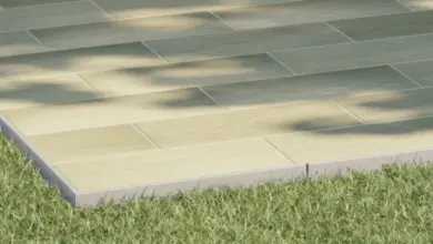 Venkovní dlažba na terase s trávníkem v pozadí.