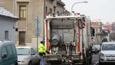 Český sběrný vozík odpadu s pracovníkem na ulici.