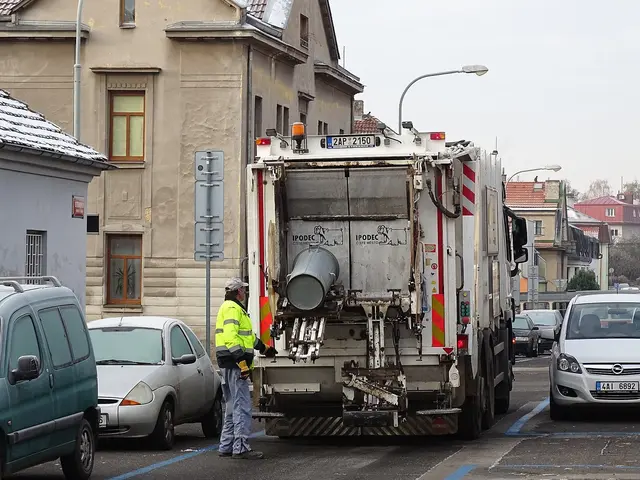 Český sběrný vozík odpadu s pracovníkem na ulici.