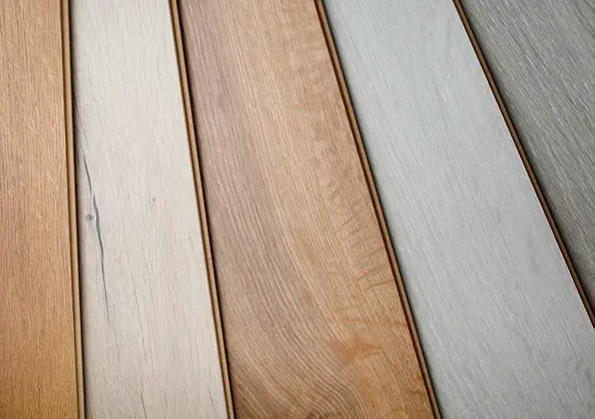 Různé druhy laminátových podlah s dřevěnou texturou v různých barvách.