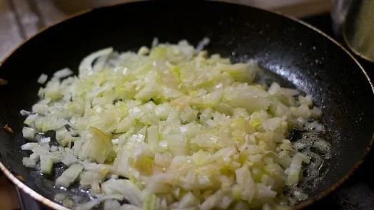 Načepkaná cibule se smaží na pánvi s olejem.