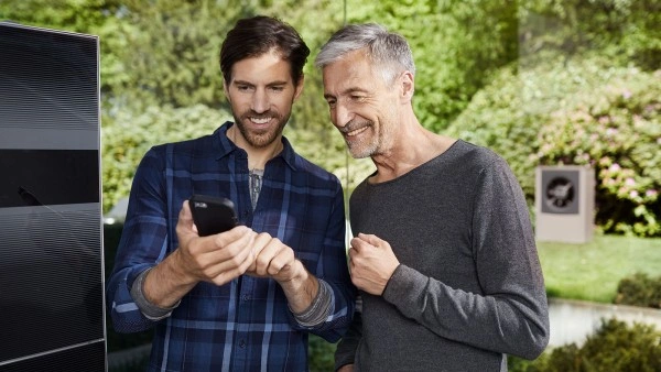 Dva muži se podívali na telefon v zahradě.