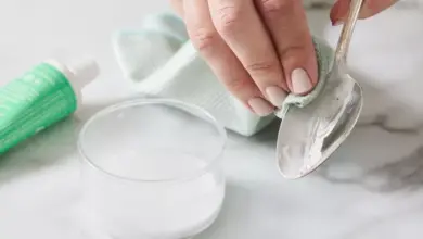 Ruční čištění starého stříbrného lžíce pastou na zuby doma.