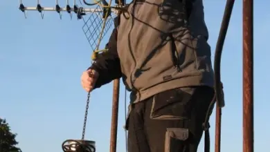 Muž na střeše s anténou v zimě