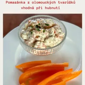 Pomazánka ze syrečků s mrkví na bílém talíři.