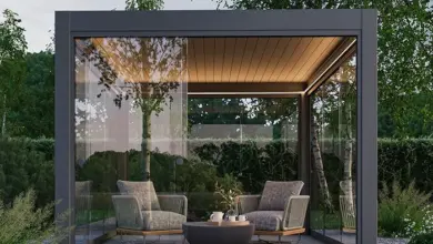 Moderní skleněná pergola s sedáky na zahradním terasu.