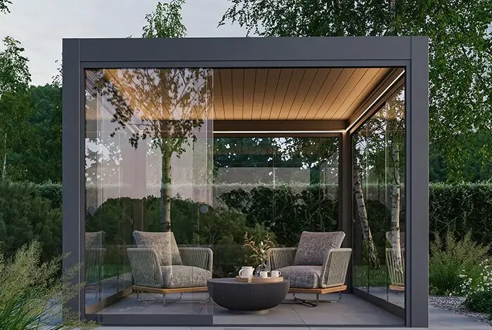 Moderní skleněná pergola s sedáky na zahradním terasu.