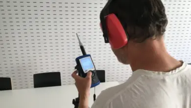 Muž měří hluk pomocí přenosného akustického analyzátoru.
