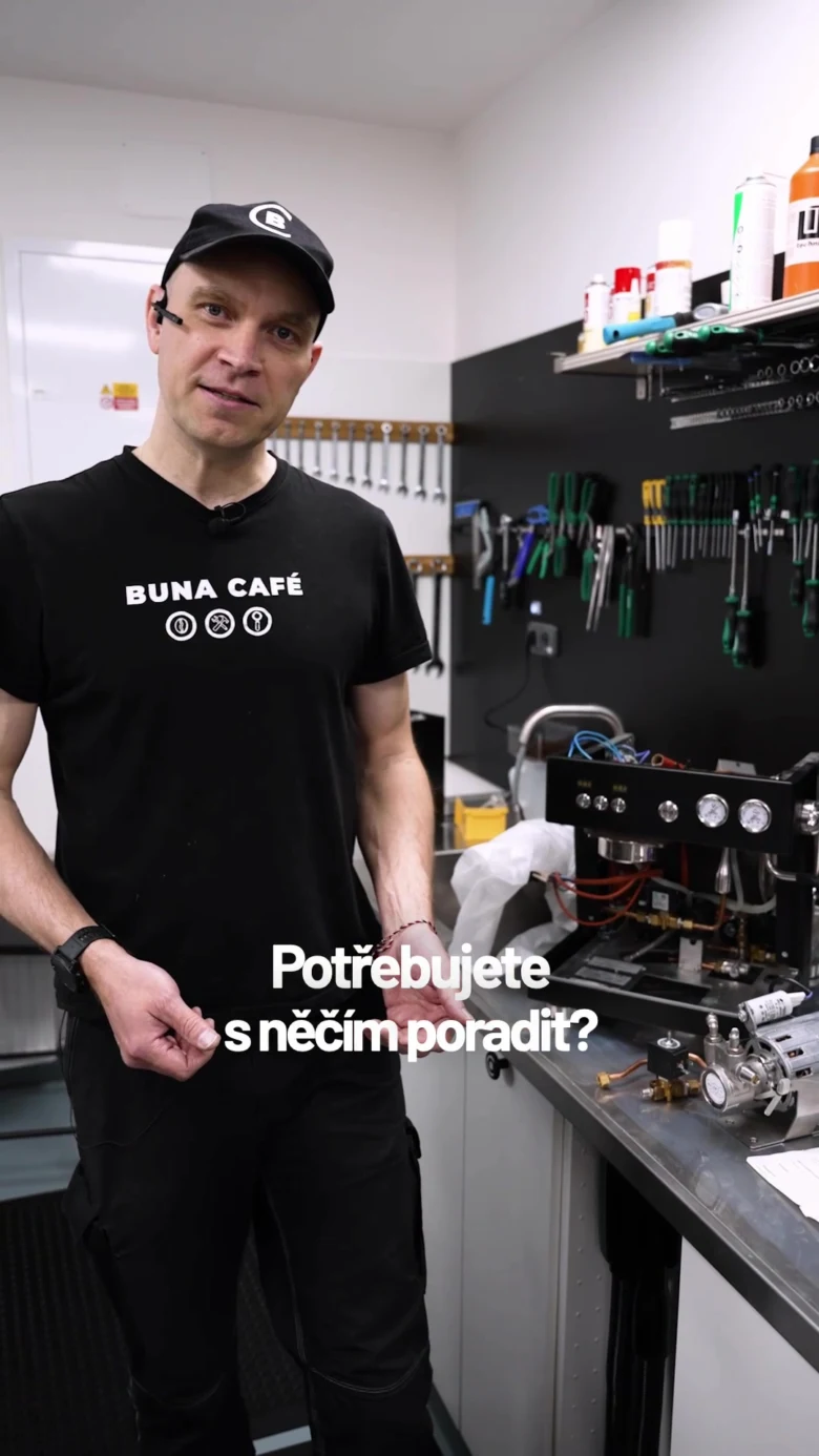 Muž u rozloženého kávovaru v dílně s nářadím.